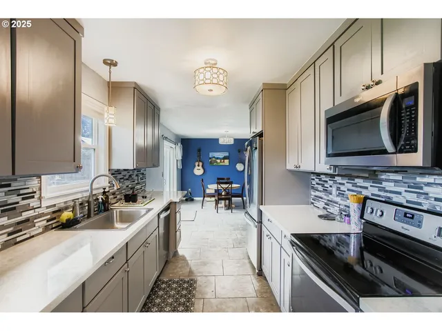a kitchen with stainless steel appliances a stove sink microwave and cabinets