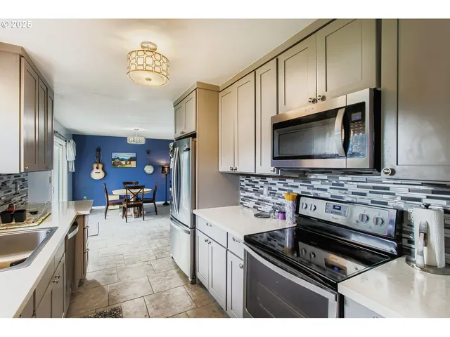 a kitchen with stainless steel appliances a stove a sink and a microwave