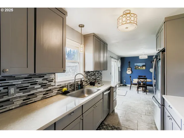 a kitchen with sink refrigerator and chairs