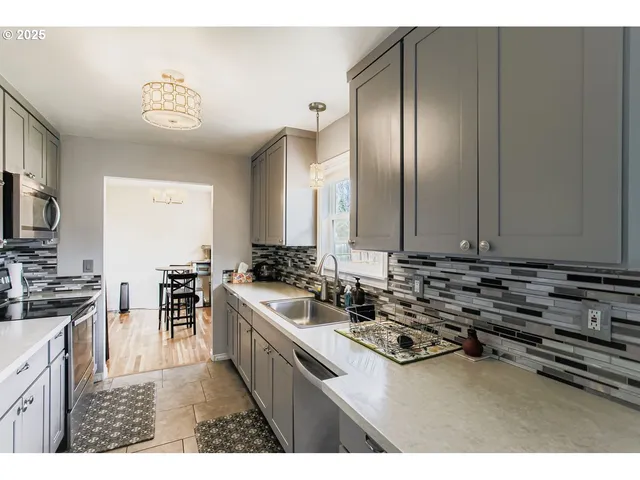 a kitchen with stainless steel appliances a stove a sink and a refrigerator