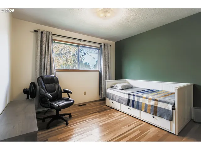 a living room with a baby bed furniture and a window