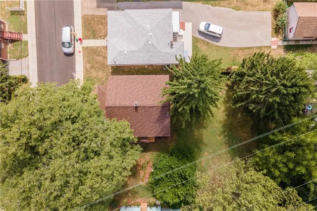 a view of a hallway with wooden floor and a bathroom