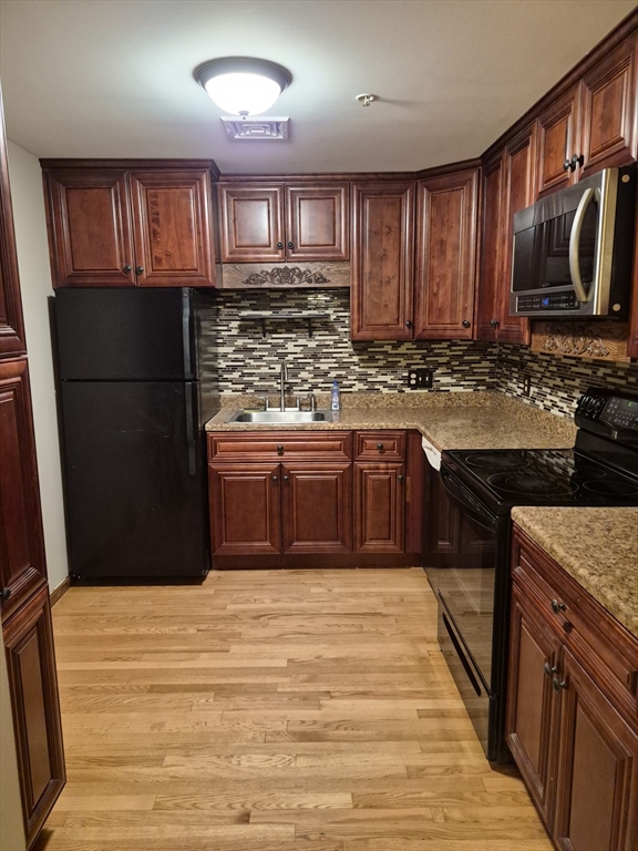 333 1st Street, Unit 209 Lowell, MA 01850 - Photo 1 of 16 a kitchen with stainless steel appliances granite countertop a stove sink and cabinets