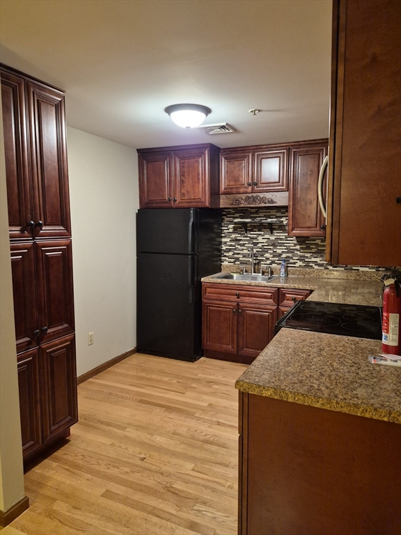 333 1st Street, Unit 209 Lowell, MA 01850 - Photo 2 of 16 a kitchen with stainless steel appliances granite countertop a refrigerator stove and sink