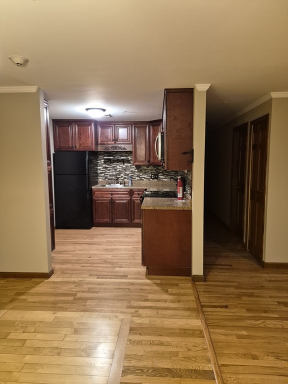 333 1st Street, Unit 209 Lowell, MA 01850 - Photo 3 of 16 a kitchen with stainless steel appliances kitchen island granite countertop a refrigerator stove and sink