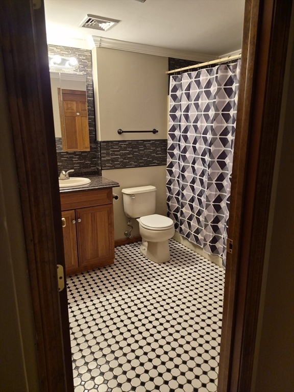 333 1st Street, Unit 209 Lowell, MA 01850 - Photo 6 of 16 a bathroom with a sink a toilet a mirror and shower