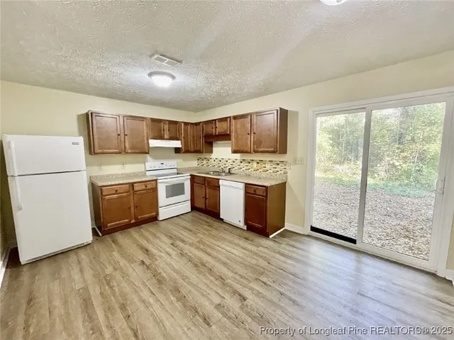 a kitchen with a stove a sink and a refrigerator