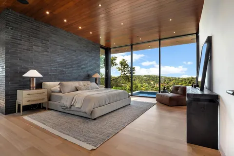 a bedroom with a bed and large window