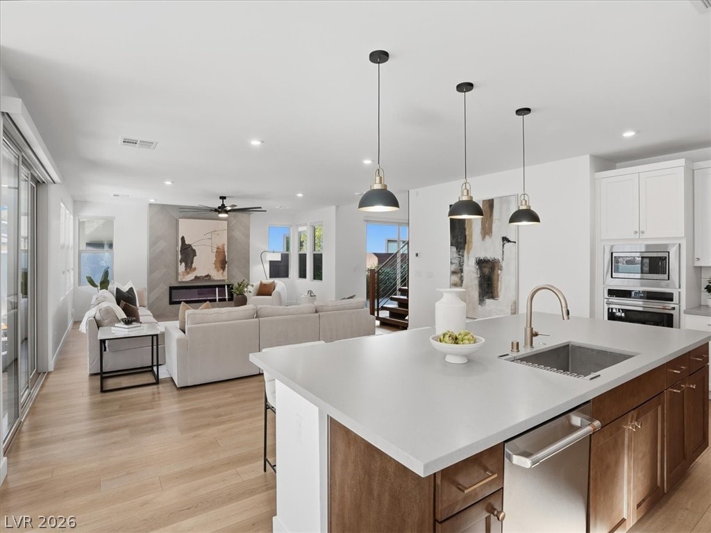 9725 Starlight Ridge Avenue Las Vegas, NV 89148 - Photo 16 of 47 This bright kitchen with a large island flows into a living area with a fireplace, creating an inviting space.