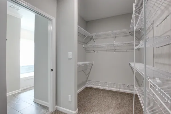 an empty room with windows and chandelier fan