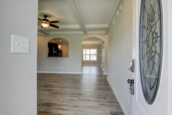 a view of an empty room with a chandelier fan