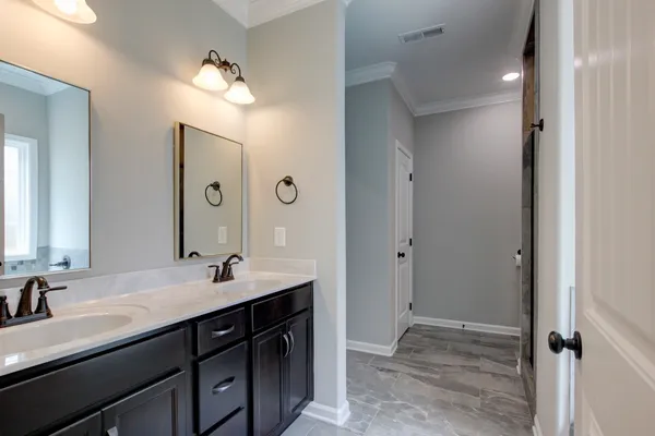 a bathroom with double vanity sinks and a mirror
