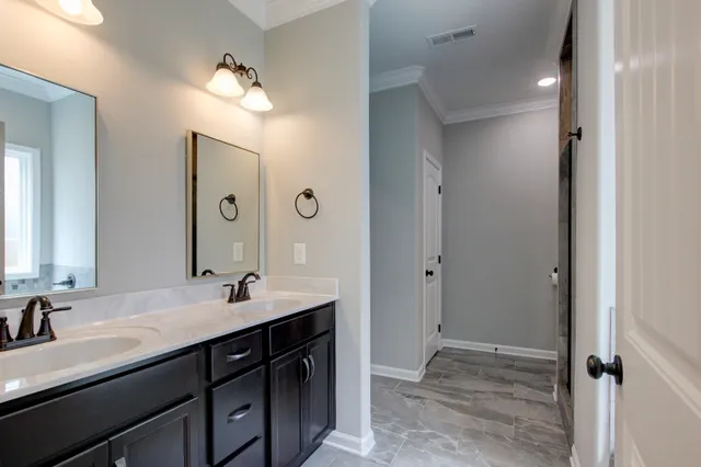 a bathroom with double vanity sinks and a mirror