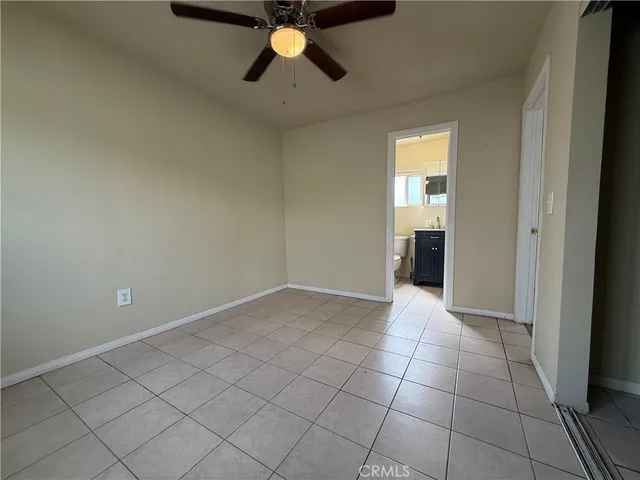 an empty room with closet and a chandelier fan