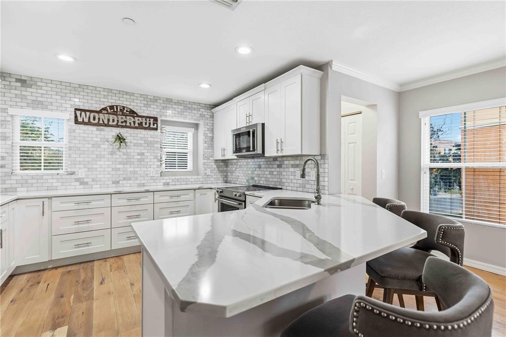 9040 White Sage Loop Lakewood Ranch, FL 34202 - Photo 12 of 59 a kitchen with a stove a sink and a refrigerator