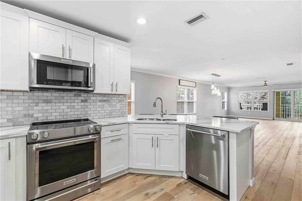 9040 White Sage Loop Lakewood Ranch, FL 34202 - Photo 13 of 59 a kitchen with stainless steel appliances granite countertop a stove top oven microwave and cabinets