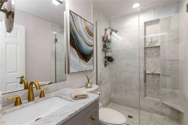 a bathroom with a sink a toilet and shower