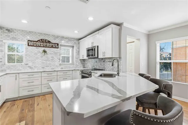 a kitchen with granite countertop a sink a stove and cabinets