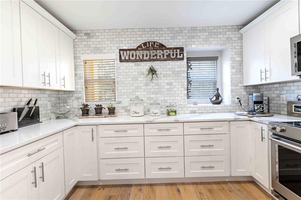 9040 White Sage Loop Lakewood Ranch, FL 34202 - Photo 37 of 59 a kitchen with granite countertop white cabinets and white appliances