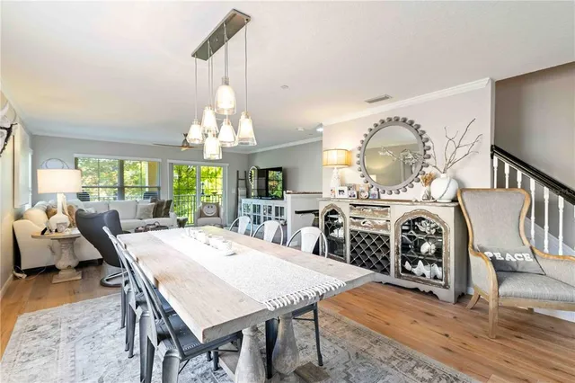 a view of a dining room with furniture a chandelier and wooden floor
