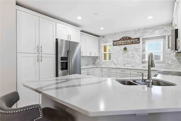 a kitchen with stainless steel appliances granite countertop a stove a sink and a refrigerator