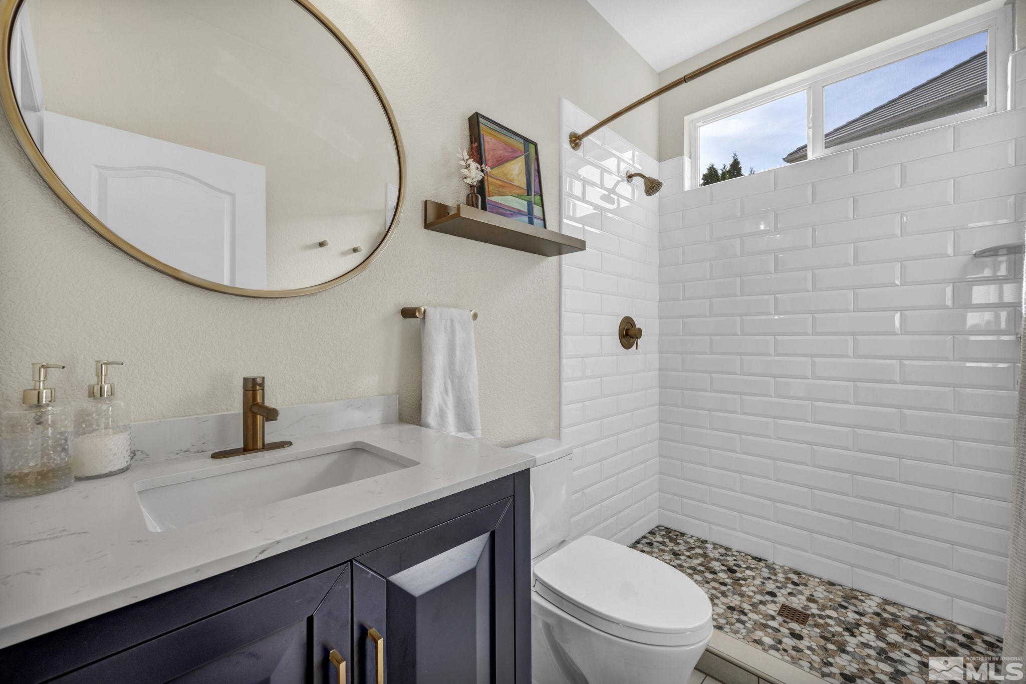 665 Paso Fino Court Reno, NV 89521 - Photo 21 of 40 a bathroom with a sink a toilet and a mirror