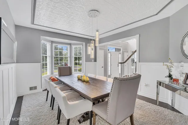 a kitchen with stainless steel appliances granite countertop a stove top oven a sink dishwasher a dining table and chairs with wooden floor