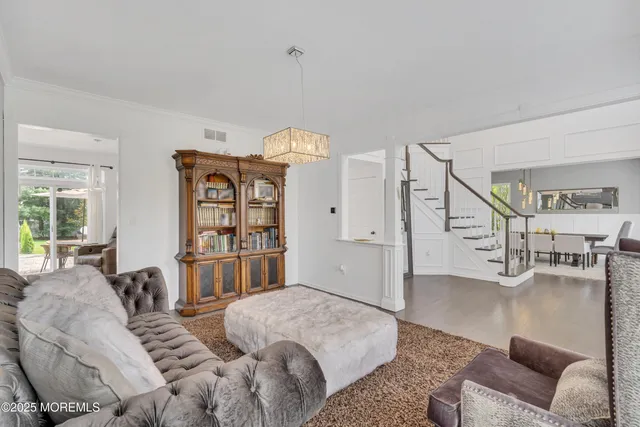 a kitchen with stainless steel appliances granite countertop a refrigerator a sink dishwasher a dining table and chairs with wooden floor