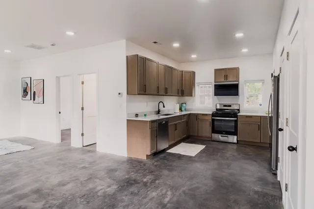 a large kitchen with a large counter top appliances and cabinets