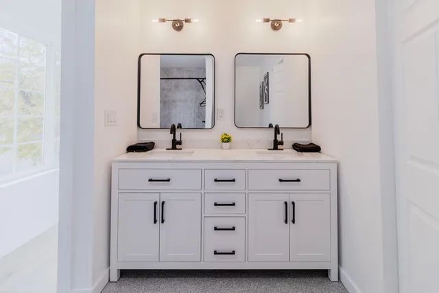 a bathroom with a granite countertop sink a toilet and shower