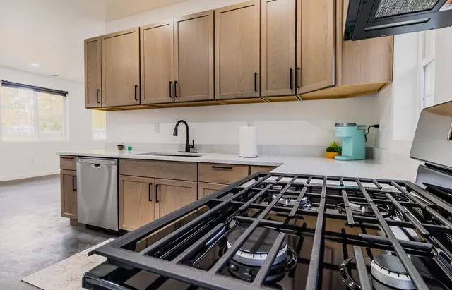 a kitchen with stainless steel appliances granite countertop a sink stove and refrigerator