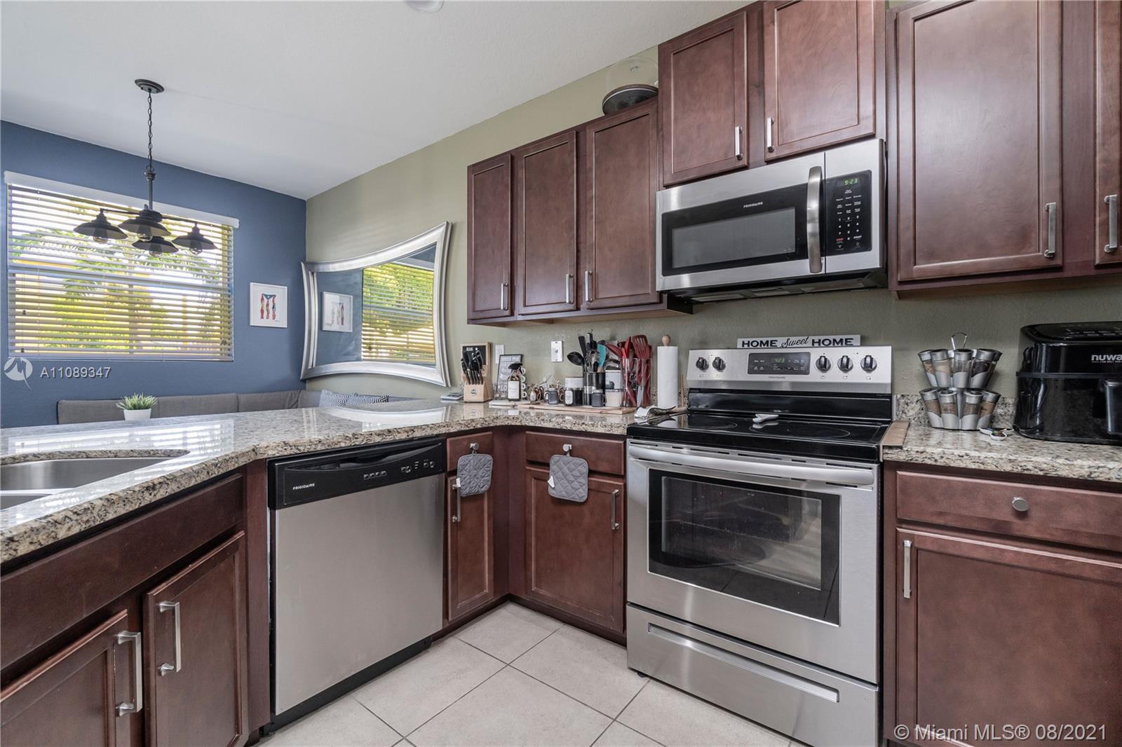 12119 Southwest 253rd Street Homestead, FL 33032 - Photo 15 of 46 a kitchen with cabinets stainless steel appliances a sink and a window