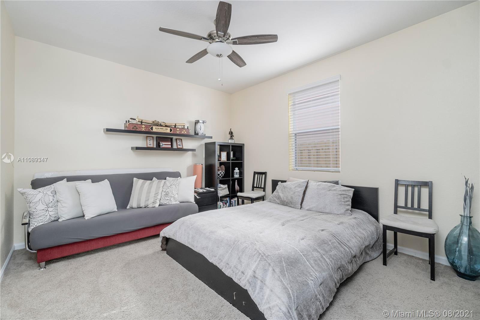 12119 Southwest 253rd Street Homestead, FL 33032 - Photo 21 of 46 a bedroom with a large bed and a chandelier