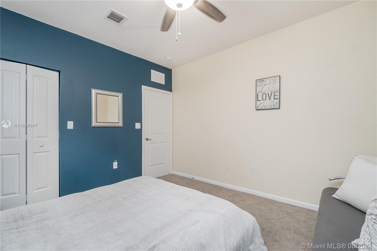12119 Southwest 253rd Street Homestead, FL 33032 - Photo 22 of 46 a bedroom with a bed and a chandelier