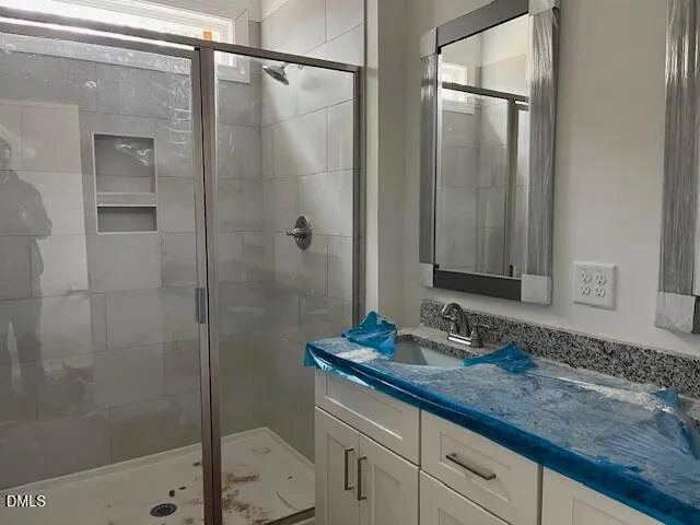 a bathroom with a granite countertop sink mirror and shower
