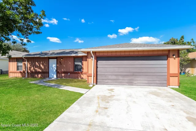 a front view of house with yard and outdoor seating