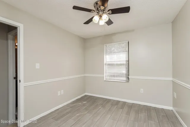 an empty room with a window and a fan