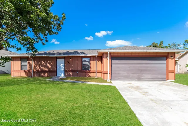 a view of a house with a yard and garage