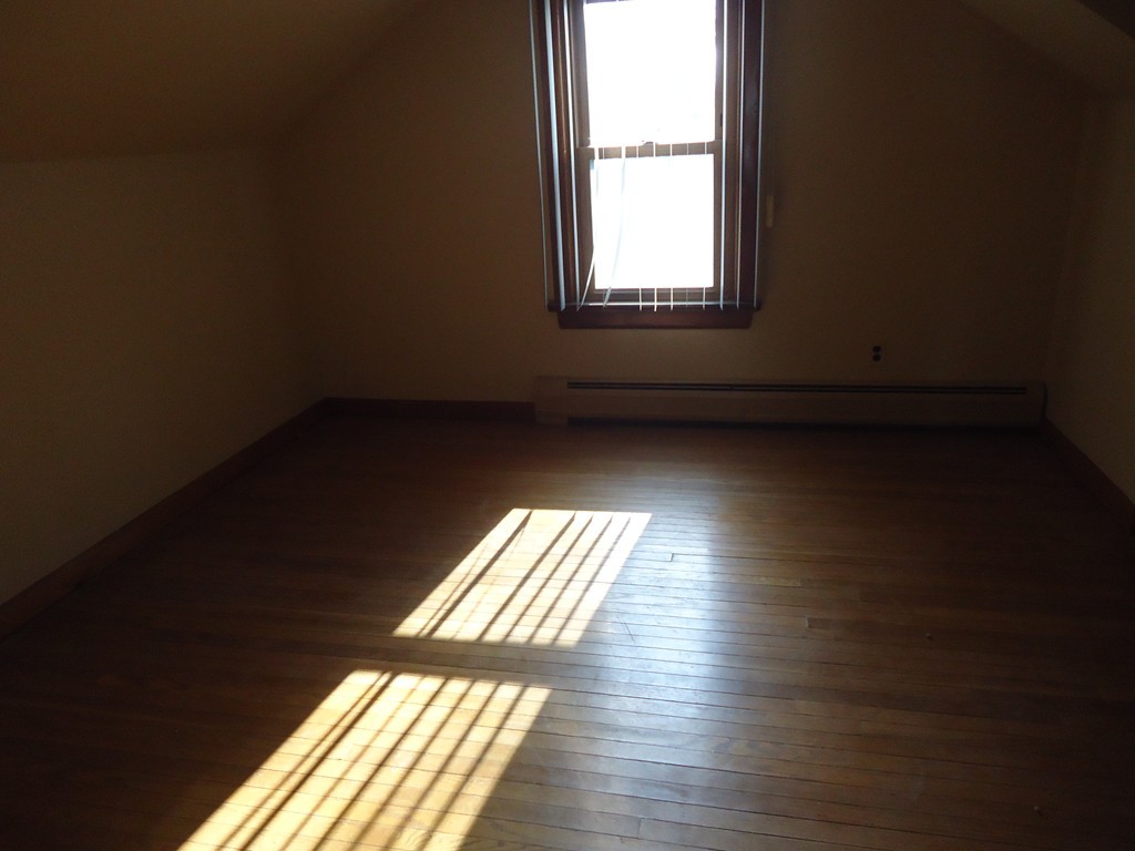 72 Victoria Street Springfield, MA 01104 - Photo 4 of 9 an empty room with wooden floor and windows