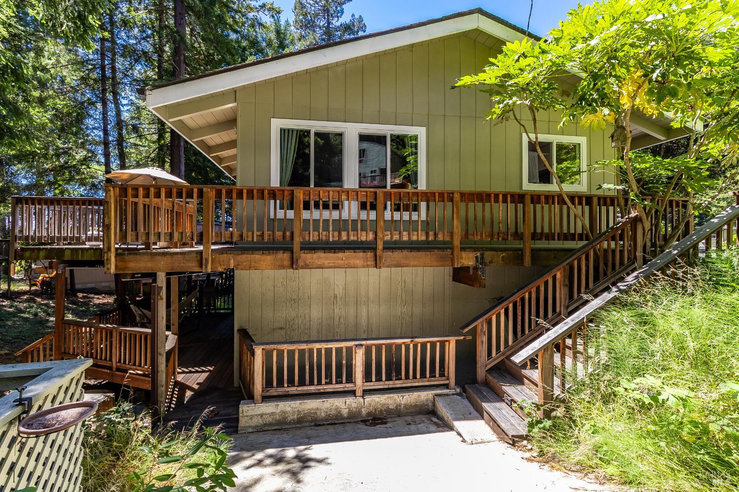 a view of a house with wooden deck and furniture