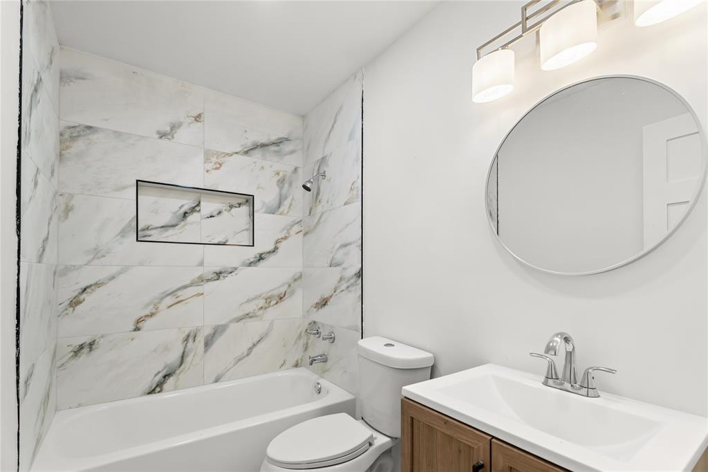 110 Hackberry Street Lancaster, TX 75146 - Photo 3 of 32 Bathroom featuring a bathtub with marble-look wall tiling and a recessed shower niche