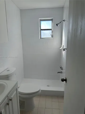 a bathroom with a granite countertop toilet a sink and shower