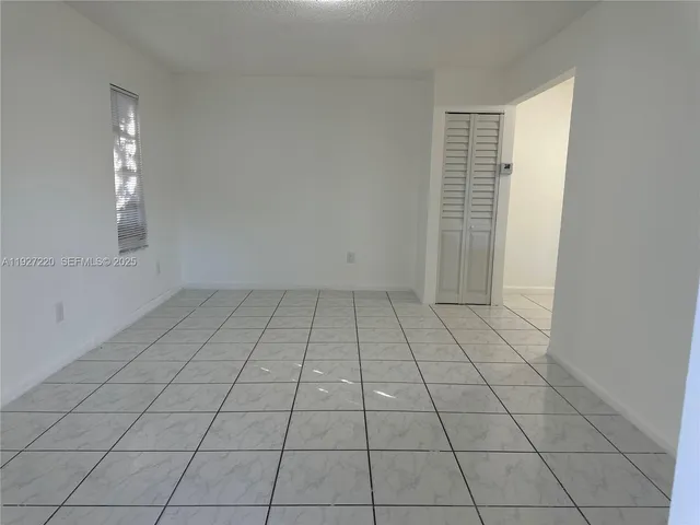 an empty room with white walls and tiles