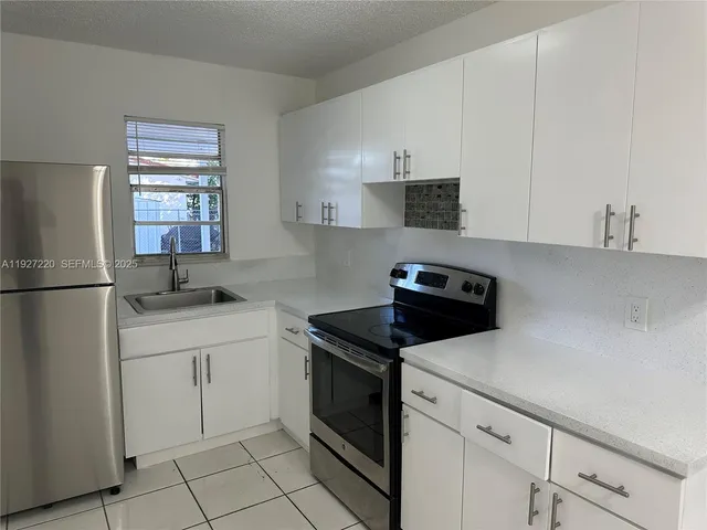 a kitchen with white cabinets sink and white appliances