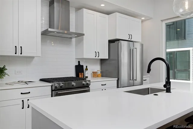 a kitchen with stainless steel appliances a refrigerator stove and sink