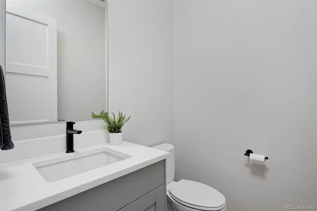 a bathroom with a sink a toilet and mirror