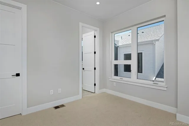 an empty room with a window and closet