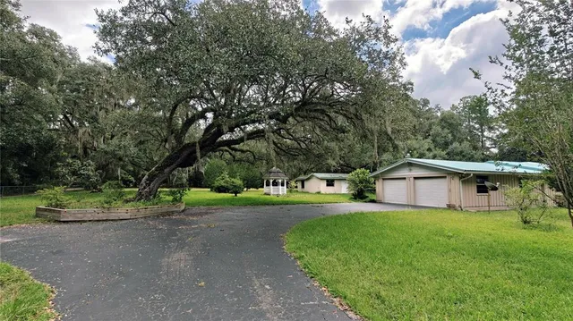 a house view with garden space and trees