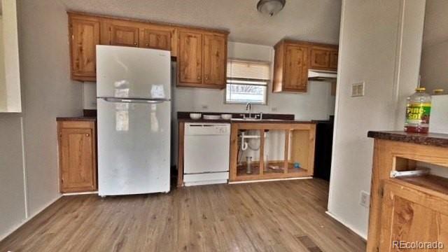 1212 Reed Lane La Junta, CO 81050 - Photo 7 of 23 a kitchen with stainless steel appliances granite countertop a refrigerator a stove a sink and a microwave oven with wooden floor
