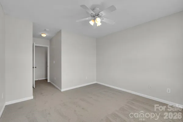 a view of an empty room with a chandelier fan